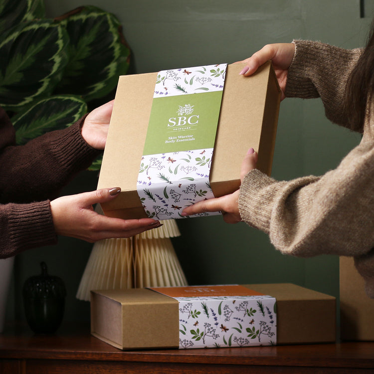 SBC Skincare gift set being passed from one person to another