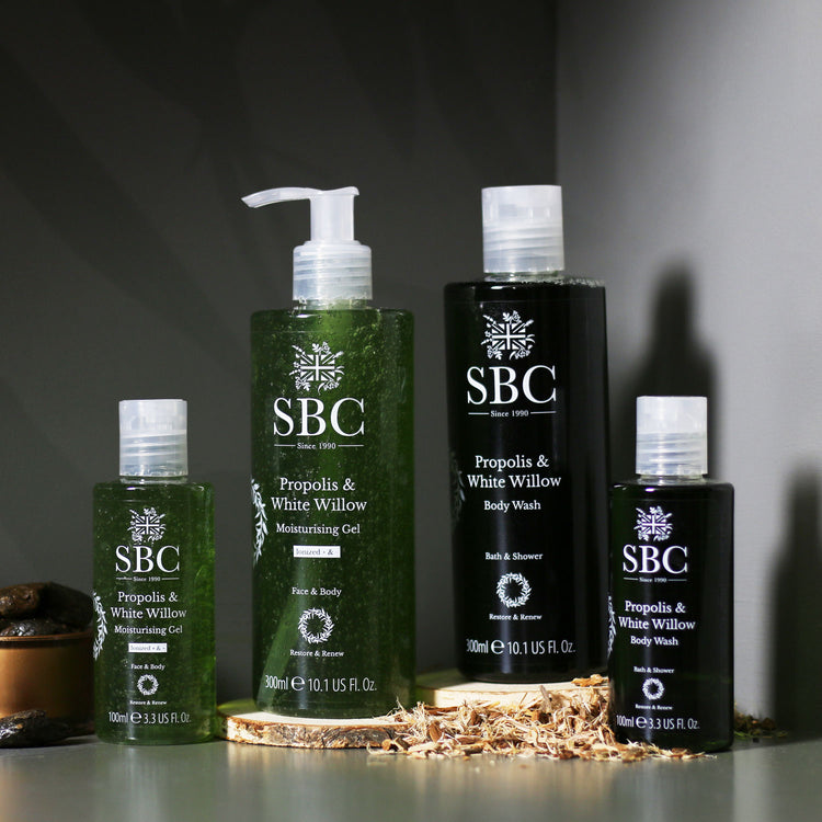 Propolis & White Willow Moisturising Gel and Body Wash on a black background with wood slices 