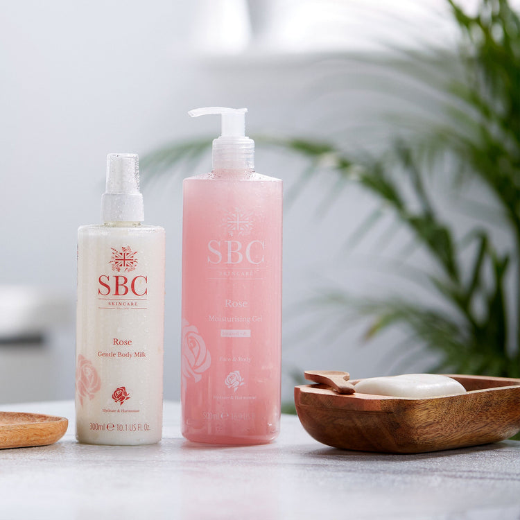 Rose Moisturising Gel and Body Milk on a bathroom counter with plants 