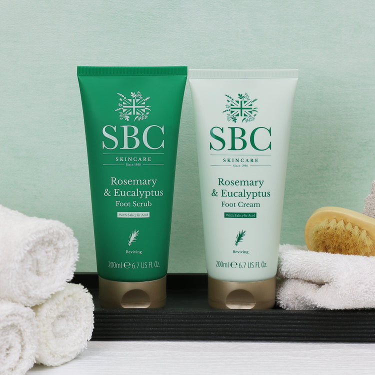 Rosemary & Eucalyptus Foot Scrub and Foot Cream in a slate dish with towels and a nail brush