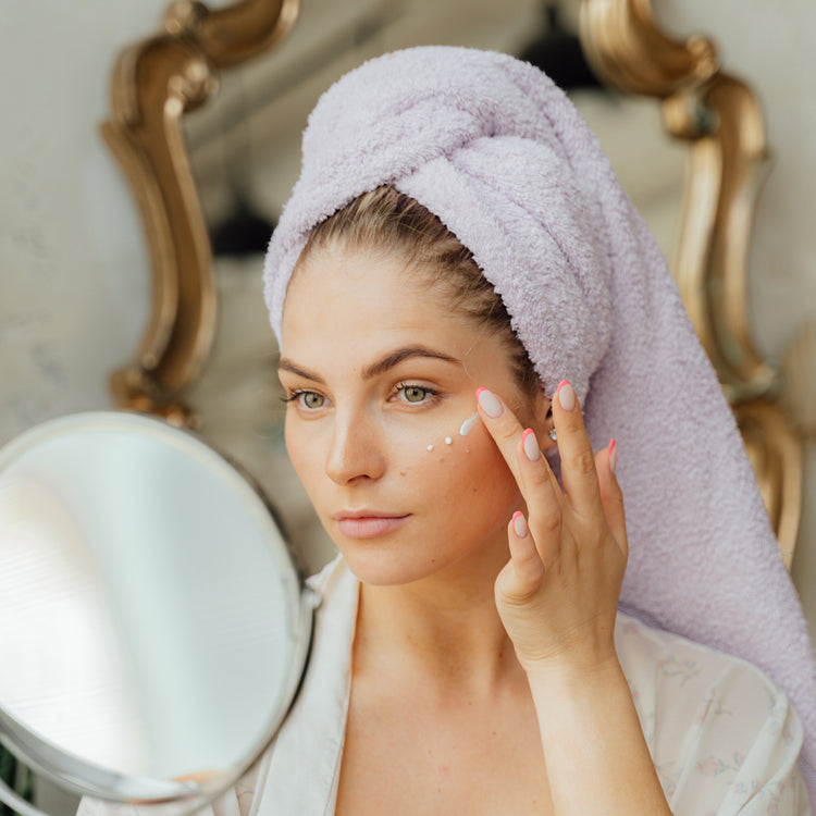 Woman applying dots of skincare under her eye 