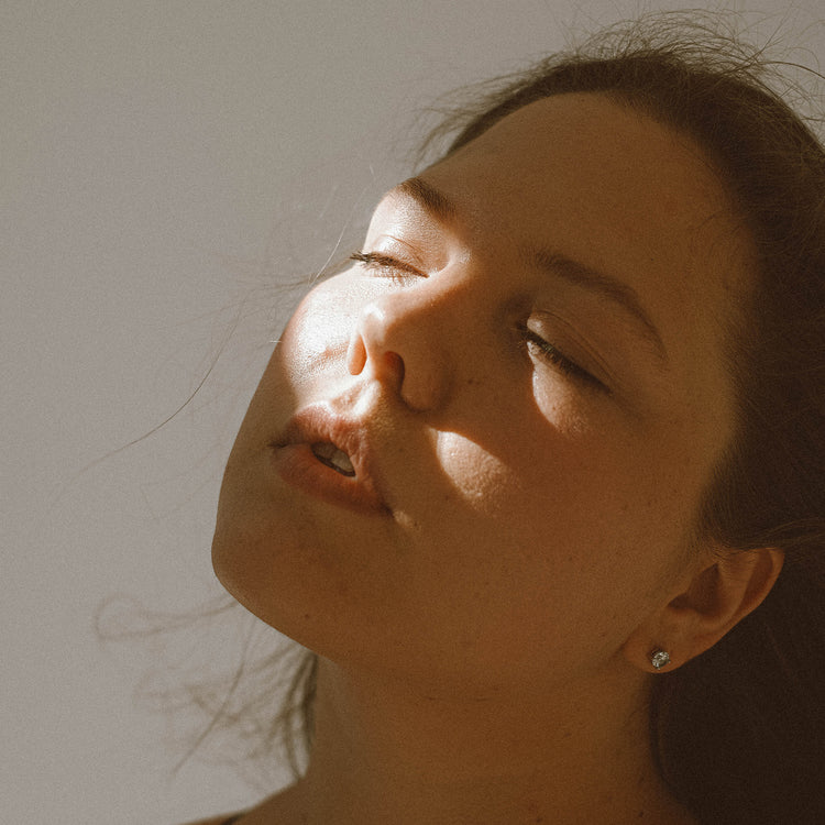 Woman looking into distance with natural light on face